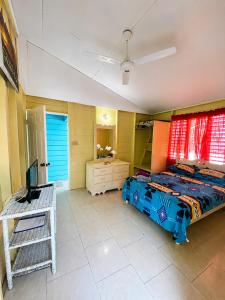 a bedroom with a bed and a desk and a television at Rooms on the 7 Mile in Negril