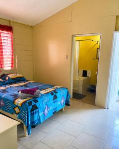 a bedroom with a bed and a bathroom with a tub at Rooms on the 7 Mile in Negril