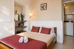 a bedroom with a bed with two white shoes on it at Alkyonis Apartments in Panormos Kalymnos