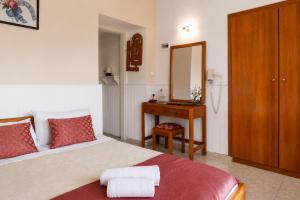 a bedroom with a bed and a table with a mirror at Alkyonis Apartments in Panormos Kalymnos