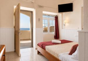 a bedroom with a bed with a view of the ocean at Alkyonis Apartments in Panormos Kalymnos