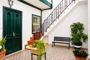 a green door and stairs with a bench at Casa Los Profesores, encanto tradicional canario en La Orotava in La Orotava