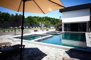 a swimming pool with an umbrella next to a building at Gravity Resort & Spa in Solotvyno