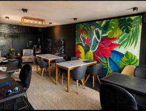 a restaurant with tables and chairs and a painting on the wall at MiCASA in Córdoba