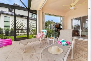 a patio with chairs and a table with hats on it at Gorgeous home with private pool & outdoor space dock in Cape Coral