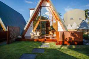 a house with a triangular roof with a yard at Pousada Recanto dos Chalés in Cruz