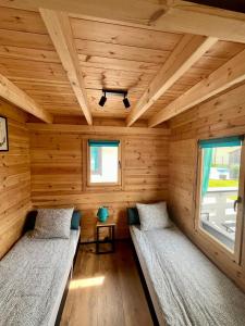 a room with two beds in a log cabin at Domki Kompas in Jantar +45 photos