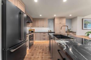 a kitchen with a black refrigerator and a sink at Designer Lakefront Condo E3 Wapato Point Chelan in Manson