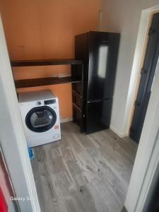 a kitchen with a refrigerator and a washing machine at Millers Ben Nevis View in Caol