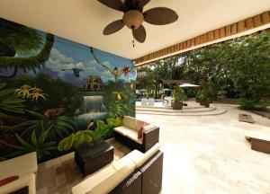 a living room with a large painting on the wall at Falling Leaves Lodge in San Ignacio