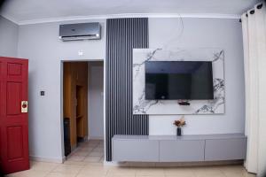 a living room with a tv on a wall at Mpala Boutique Hotel in Bulawayo