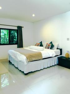 a bedroom with a large bed in a room at Watermelon House at Nong Thale Garden & Kitchen in Ban Khao Klom +32 photos