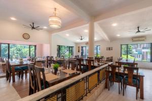 a dining room with tables and chairs and windows at Velvet Resort Khandala in Khandāla