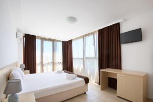 a bedroom with a bed and a large window at La Piazza Primorsko Rooms & Apartments in Primorsko