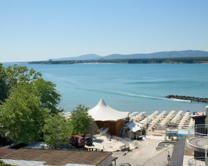 a view of a body of water with a bunch of chairs at La Piazza Primorsko Rooms & Apartments in Primorsko