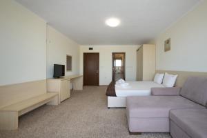 a hotel room with a bed and a couch at La Piazza Primorsko Rooms & Apartments in Primorsko +36 photos