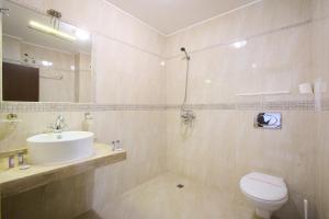 a bathroom with a sink and a toilet and a mirror at La Piazza Primorsko Rooms & Apartments in Primorsko