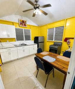 a kitchen with a wooden table and a ceiling fan at Rooms on the 7 Mile in Negril