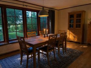 a dining room with a wooden table and chairs at Lilla lyckan in Skälsböke