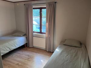 a small room with two beds and a window at Lilla lyckan in Skälsböke