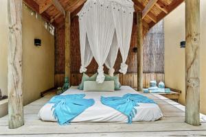 a bedroom with a large bed with a canopy at Bamboo Bonaire by Boutique Bonaire Unique Resorts in Kralendijk