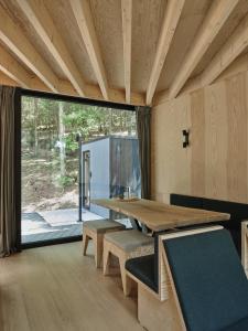 a room with a table and benches and a large window at Hutstuf Bertogne in Bertogne