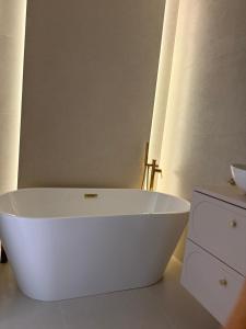 a white bath tub sitting in a bathroom at Apartament Baltic Pearl in Ustka