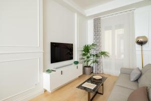 a living room with a couch and a tv at Mamma Mia Holidays - Dimore Maggiori in Bologna