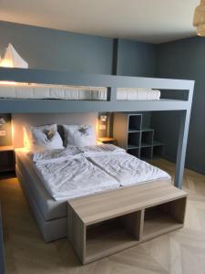 a bedroom with a bunk bed with white sheets and pillows at Het Huis - luxury villa near Tomorrowland in Willebroek +27 photos