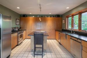 a large kitchen with wooden cabinets and a island in it at Valley View in Stowe +28 photos