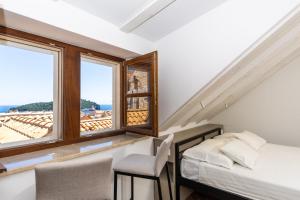 un dormitorio con una cama, sillas y una ventana en Villa Four Winds, en Dubrovnik 47 fotos más