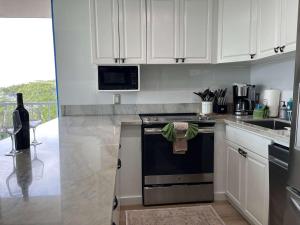 a kitchen with white cabinets and a black stove top oven at Puako Penthouse 409 - Top Floor Unit - Pool in Puako