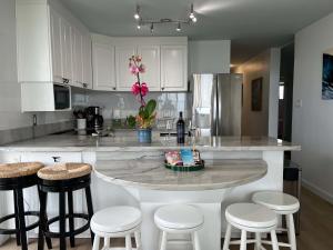 a kitchen with a large island with stools at Puako Penthouse 409 - Top Floor Unit - Pool in Puako