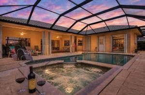 a house with a swimming pool with a glass roof at Gorgeous home with private pool & outdoor space dock in Cape Coral