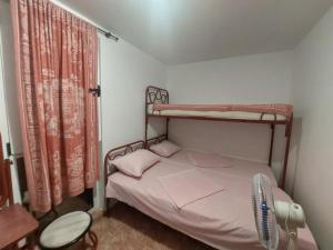 a small bedroom with a bunk bed with a fan at ADM Apartment in Bečići