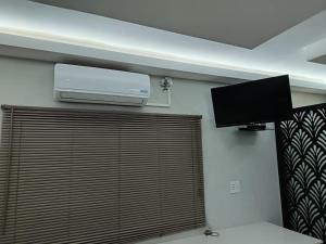 a room with a wall mounted air conditioner and a television at New Hillcrest centre guest House in Kimberley