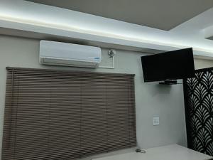 a room with a television and a wall with a window at New Hillcrest centre guest House in Kimberley