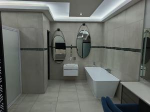 a bathroom with a sink and two mirrors at New Hillcrest centre guest House in Kimberley