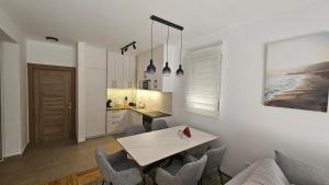 a kitchen with a table and chairs in a room at Apartman E&A in Radanovići