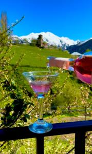a person pouring wine into a martini glass at Guesthouse Roza in Tsvirmi