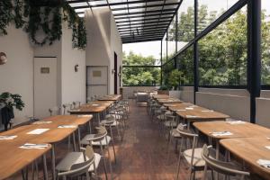 a row of tables and chairs in a room with large windows at Maria Condesa Boutique in Mexico City