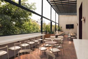 a restaurant with tables and chairs and large windows at Maria Condesa Boutique in Mexico City