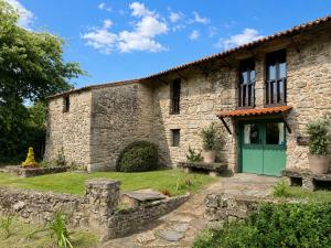 an old stone house with a green door at Elemergia in Irijoa