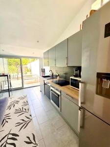 a kitchen with stainless steel appliances and a large window at L'arbousier in Cassis