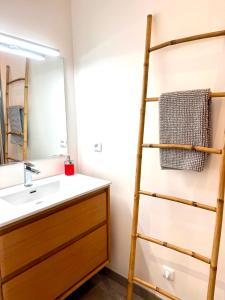 a bathroom with a sink and a towel ladder at L'arbousier in Cassis