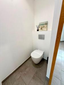 a white bathroom with a toilet in a room at L'arbousier in Cassis