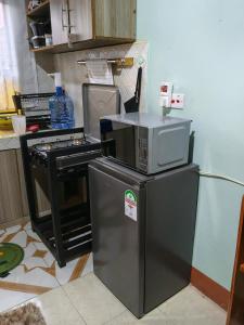 a microwave on top of a refrigerator in a kitchen at New Era Homes in Kimana