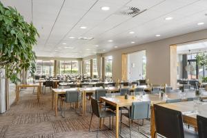 a dining room with tables and chairs at Trinity Hotel og Konference, BW Signature Collection in Fredericia
