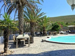 a patio with a table and chairs next to a pool at Villa Torre Macastre, Valencia in Macastre