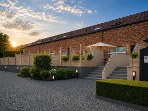 a brick building with stairs and a sunset in the background at PROGÎTES "L'escale" in Quiévrain